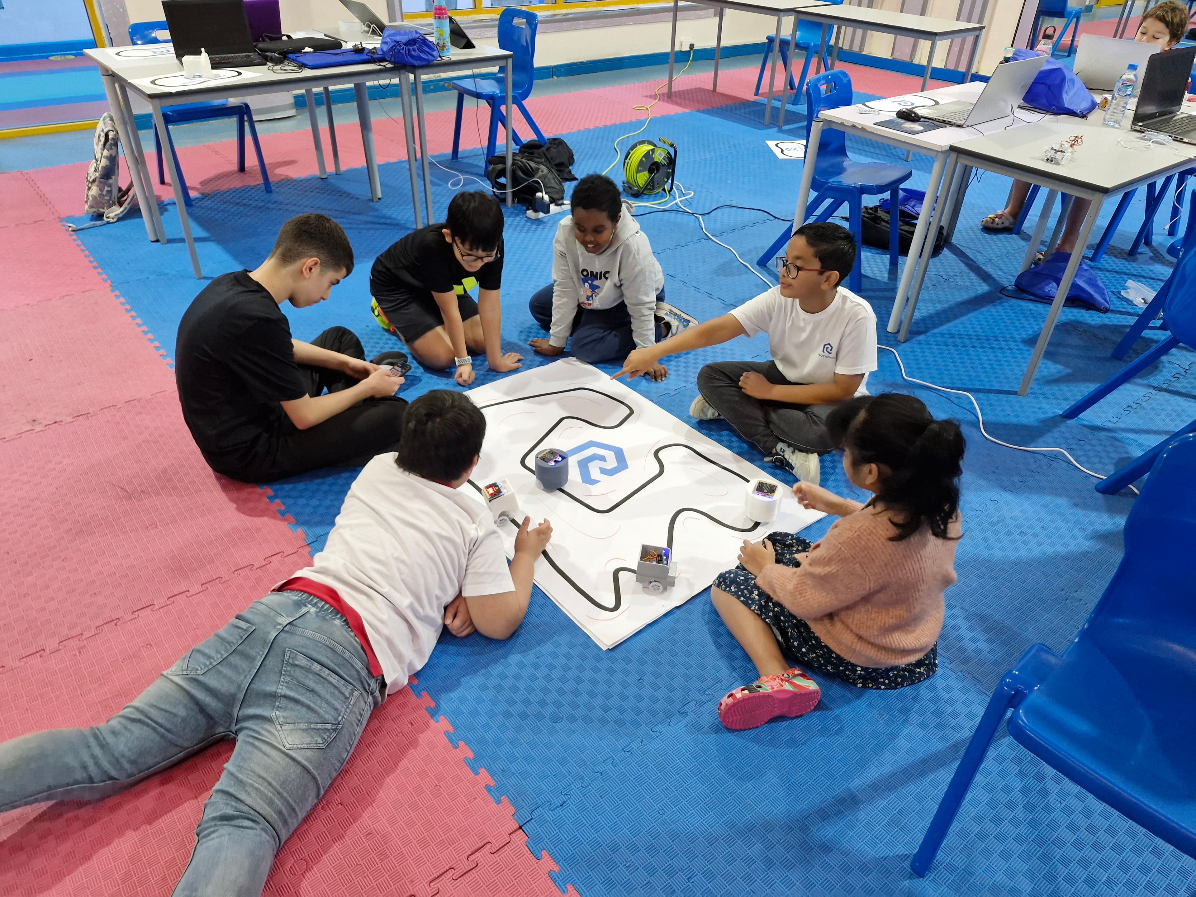 Students testing line-following robots on a workshop track