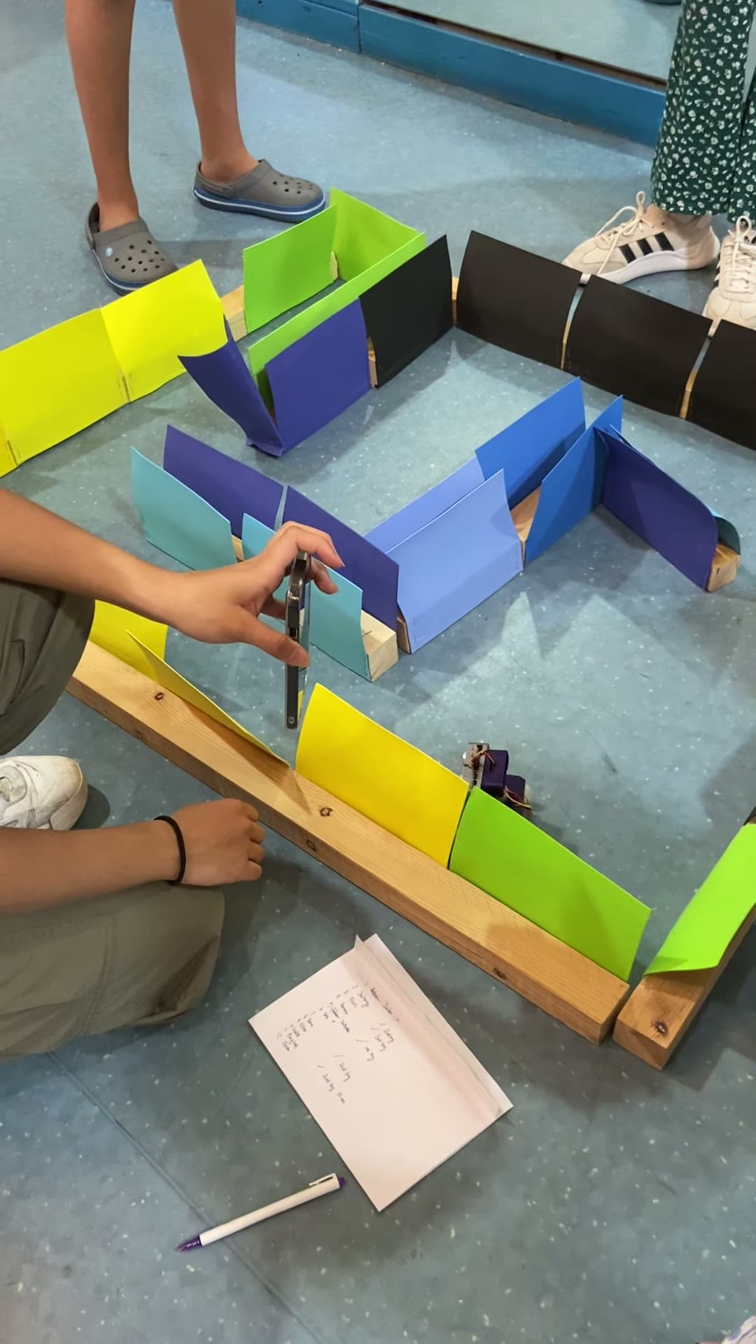 Student hand placing a robot into a maze-navigation course