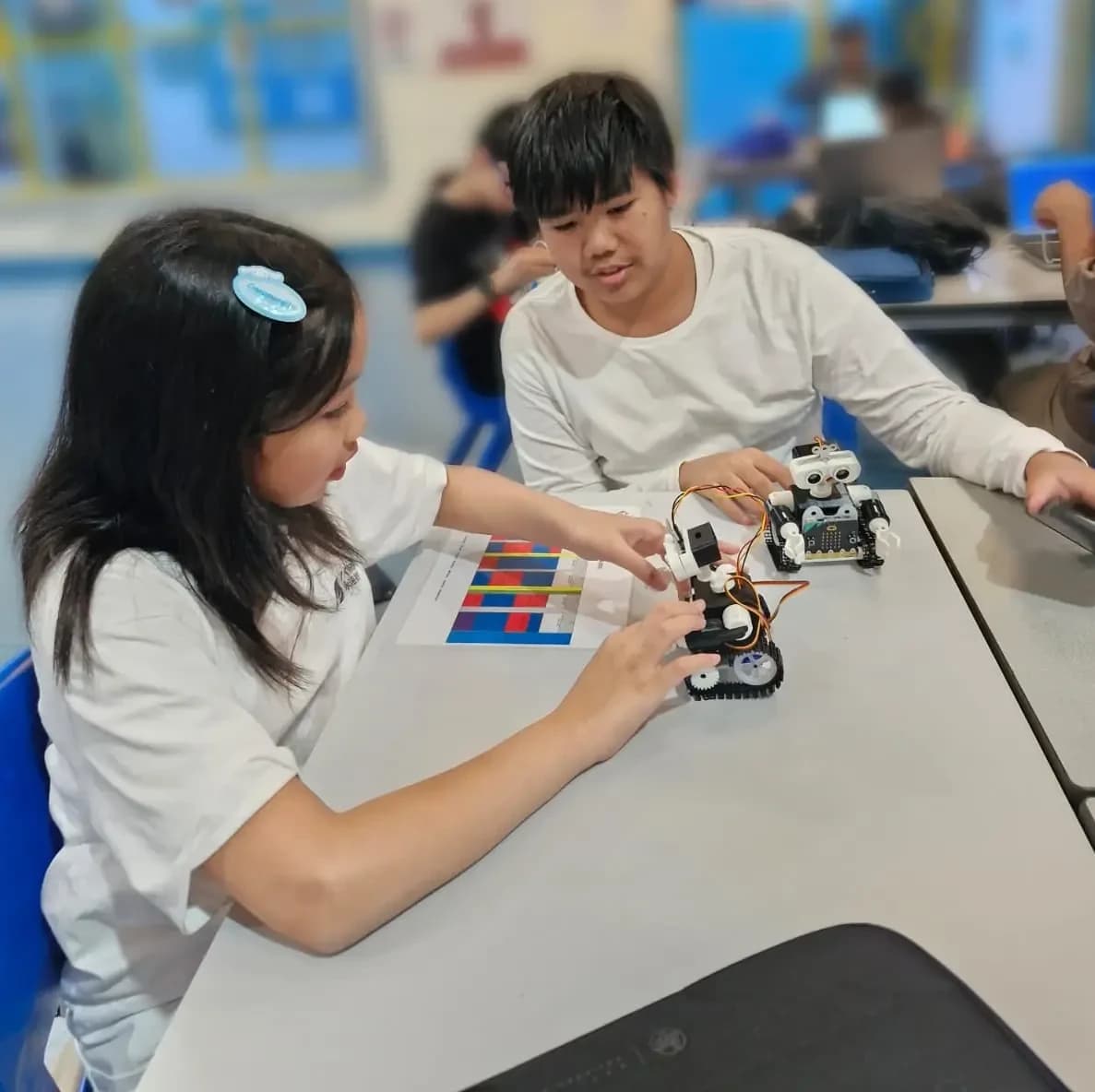 Students assembling and programming robots during class